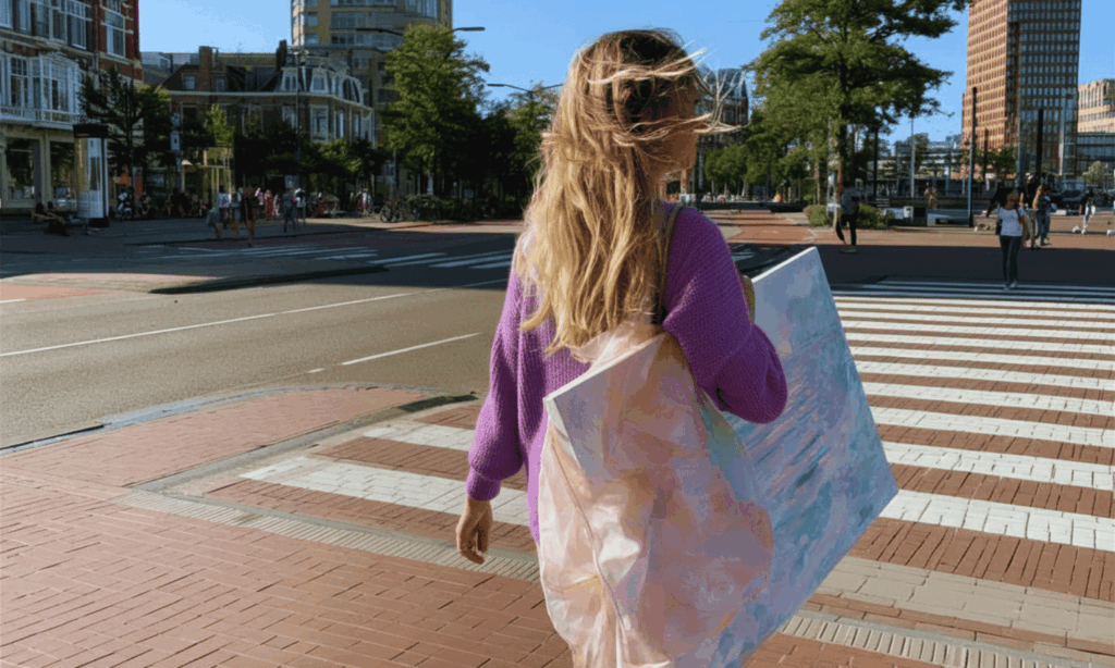 foto van vrouw met schilderij onder haar arm in den haag