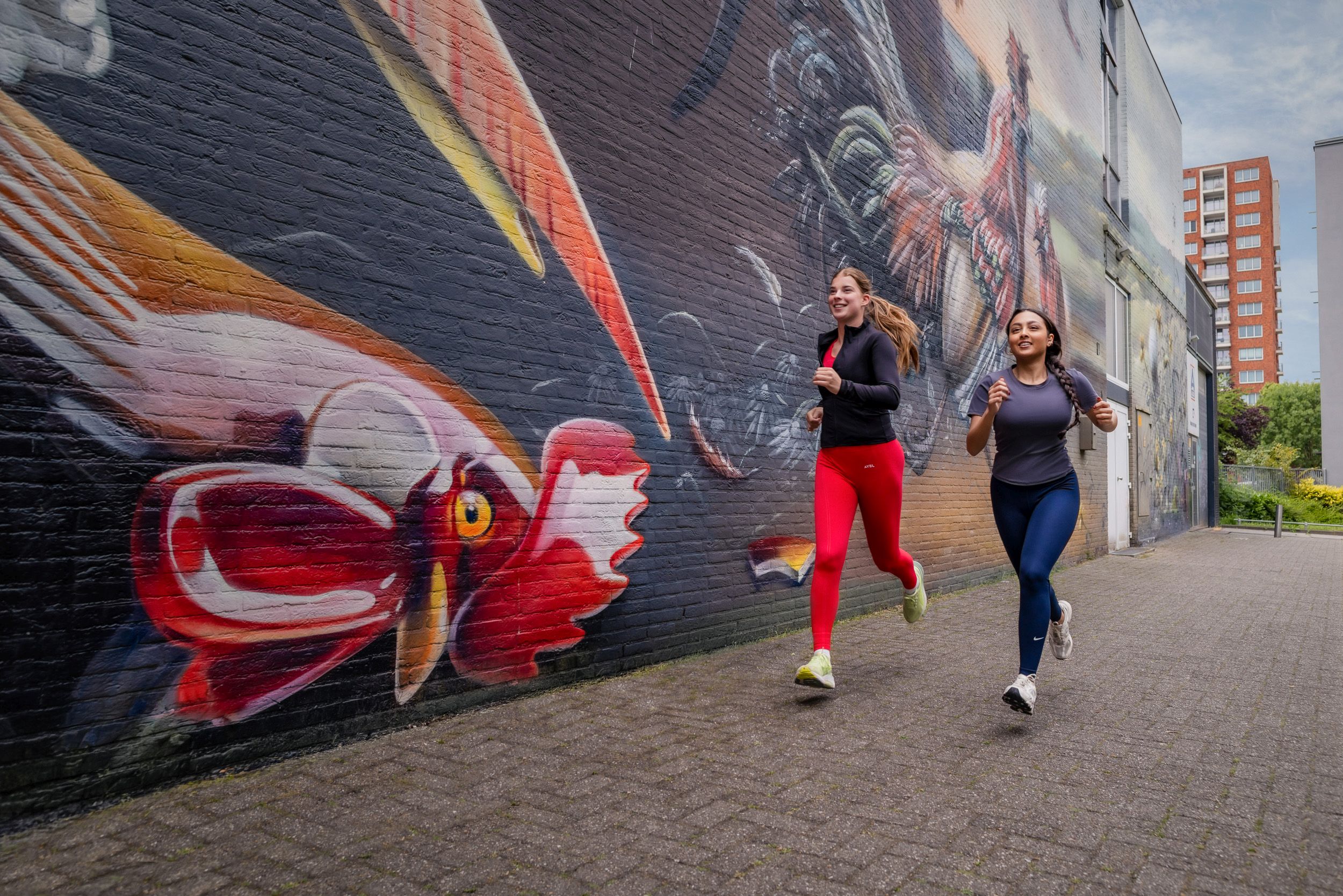 foto van vrouwen die hardlopen langs muurschilderingen in het project van het Mauritshuis